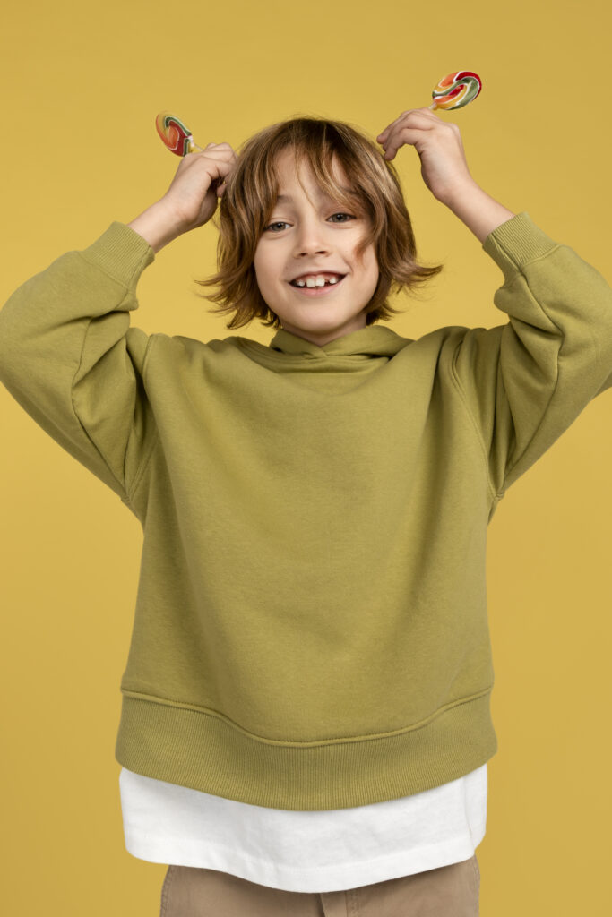 portrait teenage boy holding two lollypops